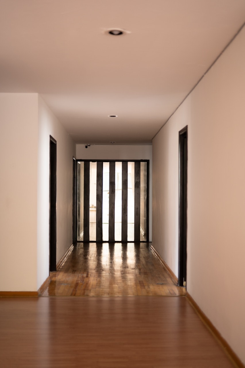 Pasillo con piso de madera y puerta de herrería